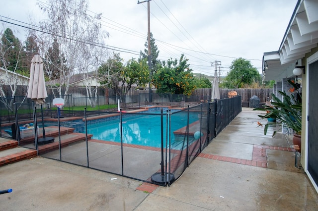 view of swimming pool featuring a patio area, a fenced backyard, and a pool with connected hot tub