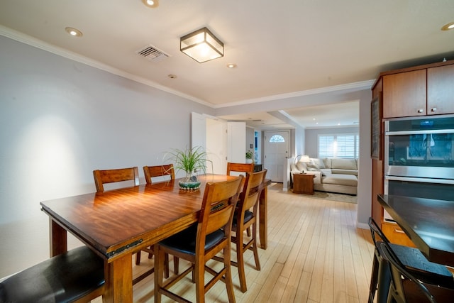 dining space featuring light wood finished floors, visible vents, crown molding, and recessed lighting