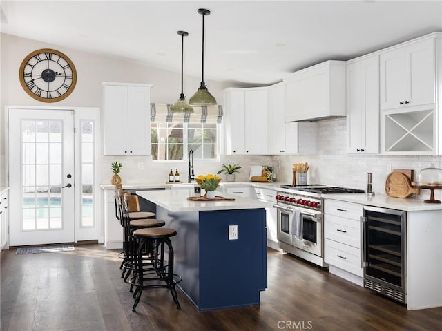 kitchen featuring double oven range, wine cooler, light countertops, and a center island