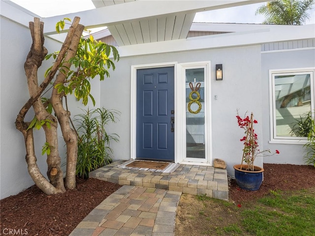 view of exterior entry with stucco siding