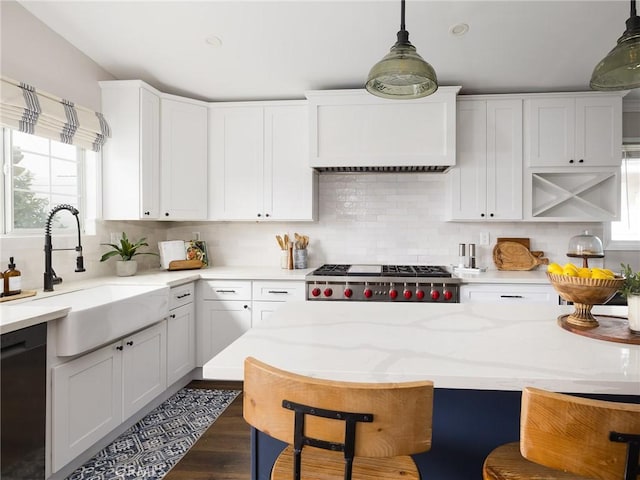 kitchen featuring pendant lighting, white cabinets, a sink, range, and dishwasher