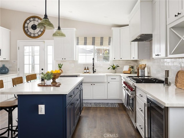 kitchen featuring white cabinets, a breakfast bar area, light countertops, and a sink