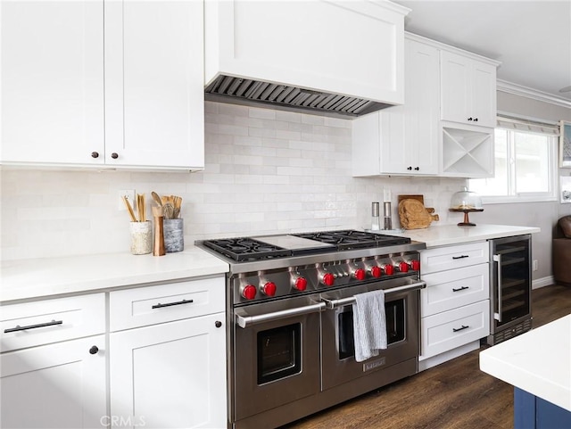 kitchen with white cabinets, custom range hood, range with two ovens, and light countertops