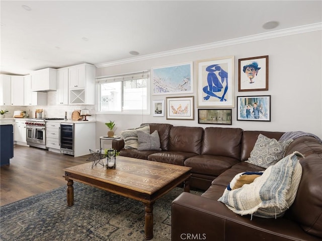 living area with beverage cooler, dark wood-style flooring, and crown molding