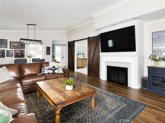 living room featuring ornamental molding, wood finished floors, and a barn door