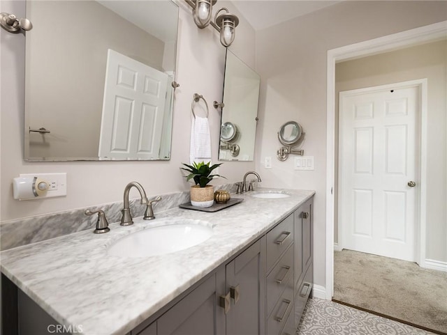 full bath with double vanity, a sink, and baseboards