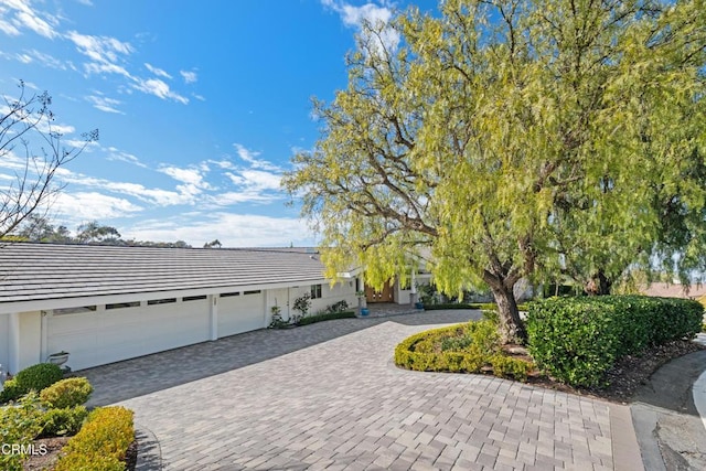 view of front facade with a garage and decorative driveway