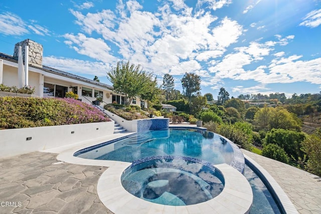 view of pool featuring a pool with connected hot tub