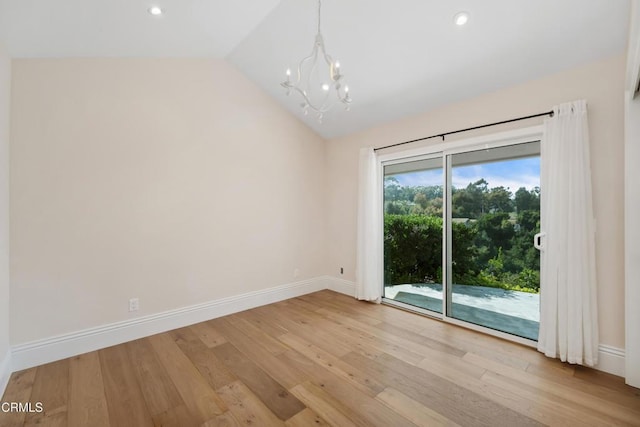 empty room featuring lofted ceiling, an inviting chandelier, light wood-style flooring, and baseboards