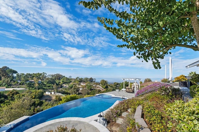 view of pool with a patio, a pergola, and an in ground hot tub