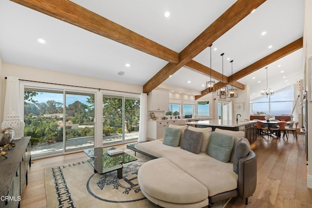 living area featuring light wood finished floors, beamed ceiling, recessed lighting, and a notable chandelier