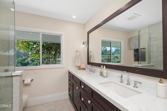 full bath featuring double vanity, tile patterned flooring, a sink, and baseboards