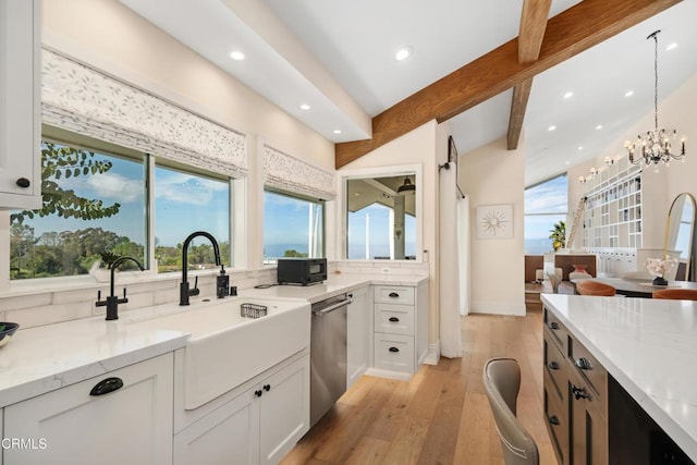 kitchen featuring light stone counters, beamed ceiling, a sink, light wood-type flooring, and stainless steel dishwasher