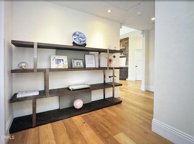 interior space with baseboards, wood finished floors, and recessed lighting