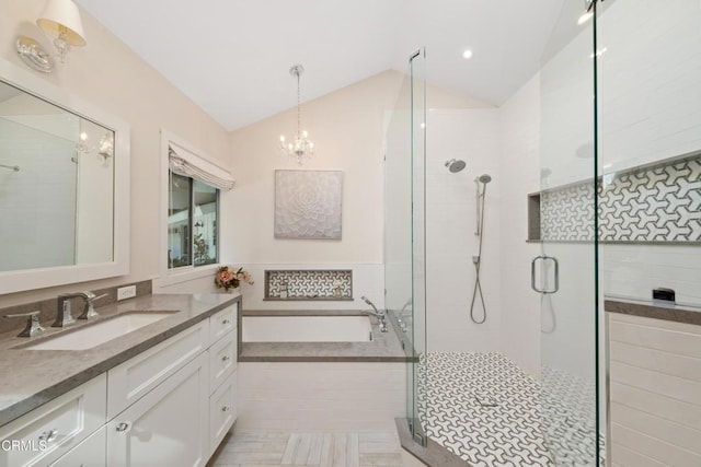 full bathroom featuring a garden tub, a notable chandelier, lofted ceiling, a stall shower, and vanity