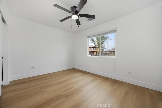 unfurnished room with visible vents, ceiling fan, light wood-style flooring, and baseboards