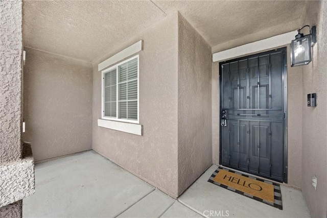 doorway to property featuring stucco siding