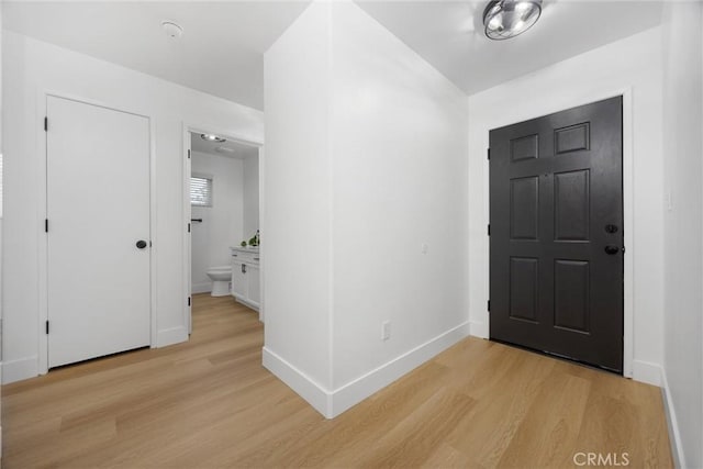 foyer entrance with light wood-type flooring and baseboards