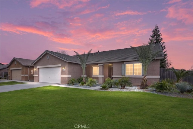 single story home with a garage, driveway, fence, a yard, and stucco siding