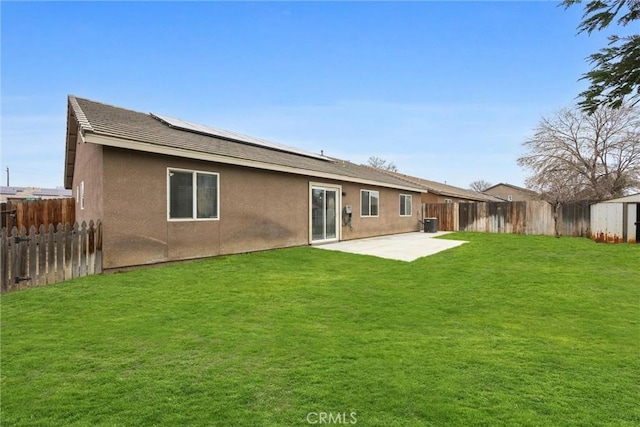 rear view of property with a yard, a fenced backyard, stucco siding, and a patio