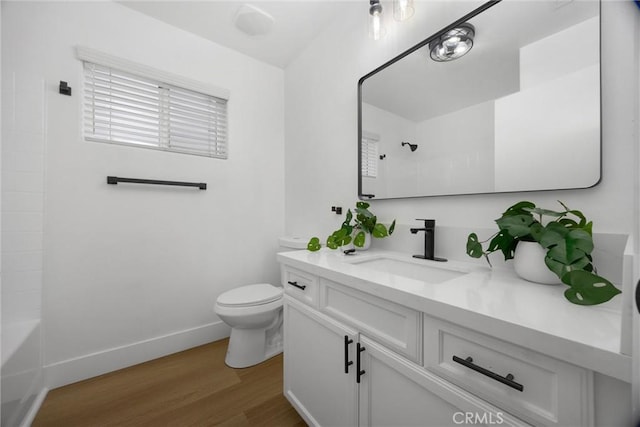 bathroom featuring baseboards, toilet, wood finished floors, vanity, and shower / washtub combination