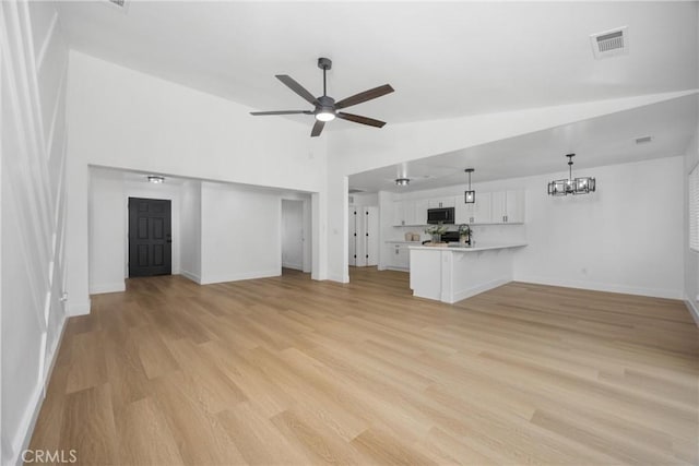 unfurnished living room featuring baseboards, visible vents, light wood finished floors, and ceiling fan with notable chandelier