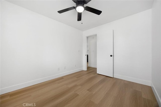 unfurnished bedroom featuring baseboards, a ceiling fan, and light wood-style floors