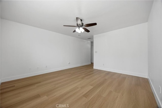 empty room with light wood-style floors, ceiling fan, and baseboards