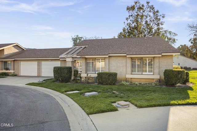 single story home featuring an attached garage, a shingled roof, concrete driveway, stucco siding, and a front yard