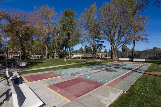 view of home's community featuring shuffleboard, a yard, and fence