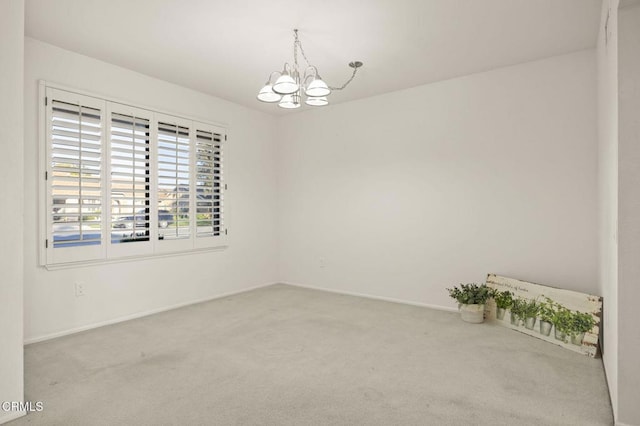 unfurnished room with light colored carpet, a notable chandelier, and baseboards