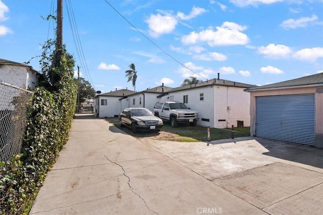 exterior space featuring a garage, fence, and concrete driveway