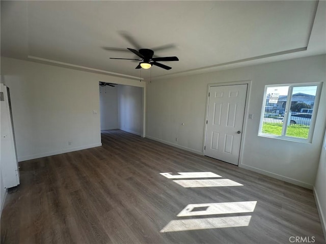 unfurnished bedroom with a ceiling fan, baseboards, and dark wood-type flooring