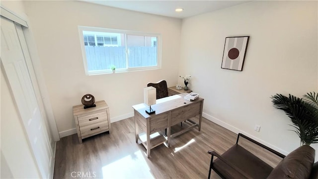 home office featuring light wood-type flooring and baseboards