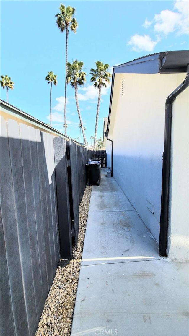 view of property exterior featuring stucco siding, a patio, and fence