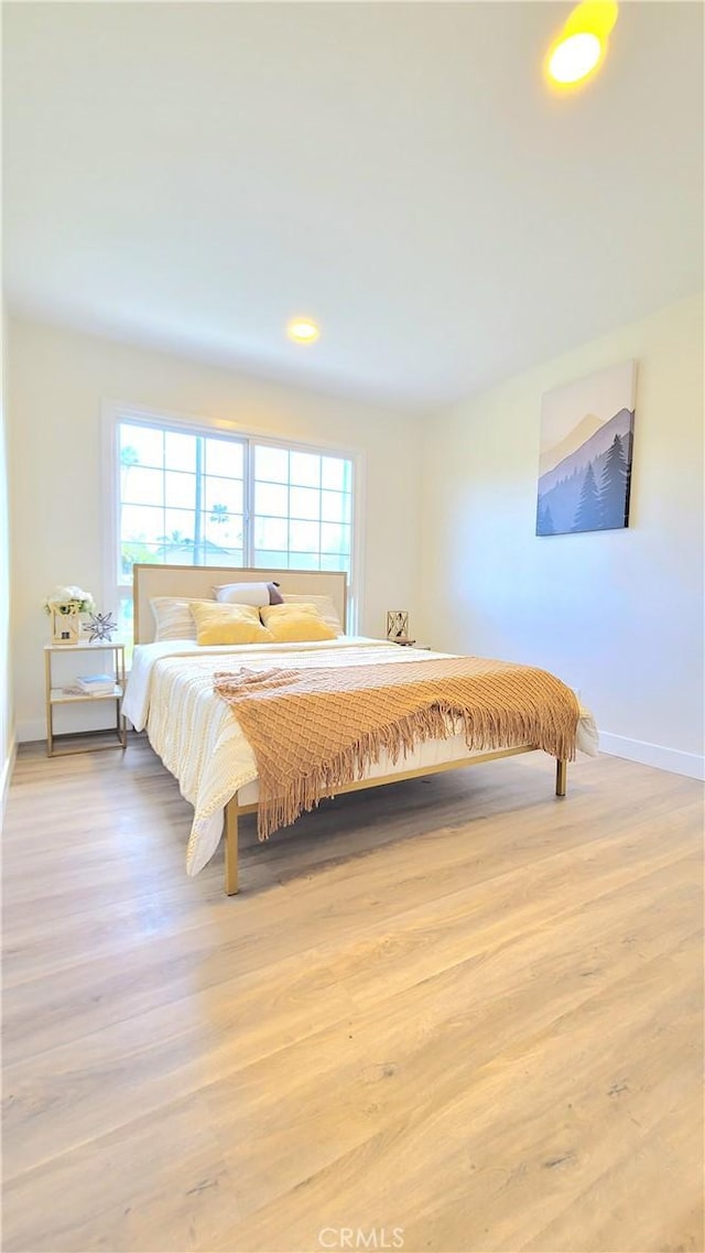 bedroom featuring light wood-style flooring and baseboards