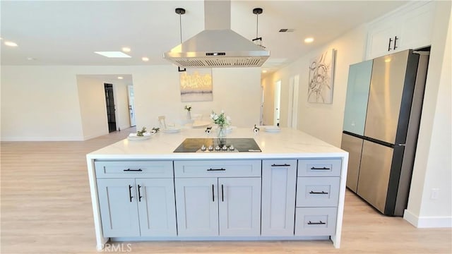 kitchen featuring black electric cooktop, white cabinets, freestanding refrigerator, island exhaust hood, and pendant lighting