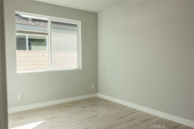 unfurnished room with light wood finished floors and baseboards