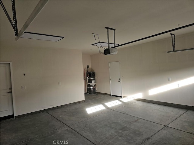 garage featuring baseboards, secured water heater, and a garage door opener