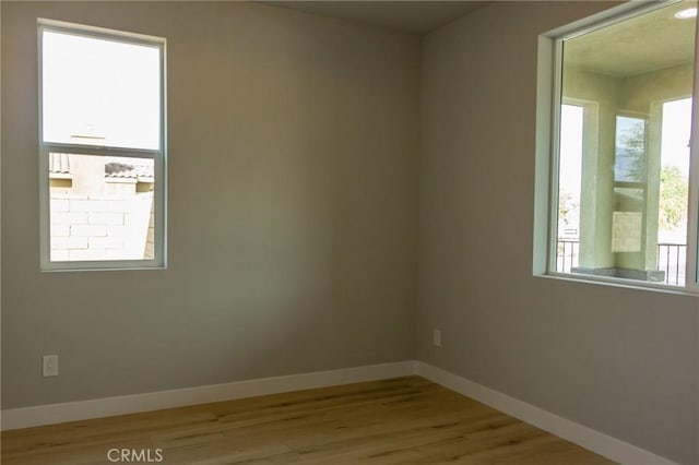 empty room featuring baseboards and light wood-style floors