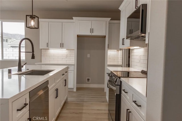 kitchen featuring white cabinetry, range with electric cooktop, dishwasher, and decorative light fixtures