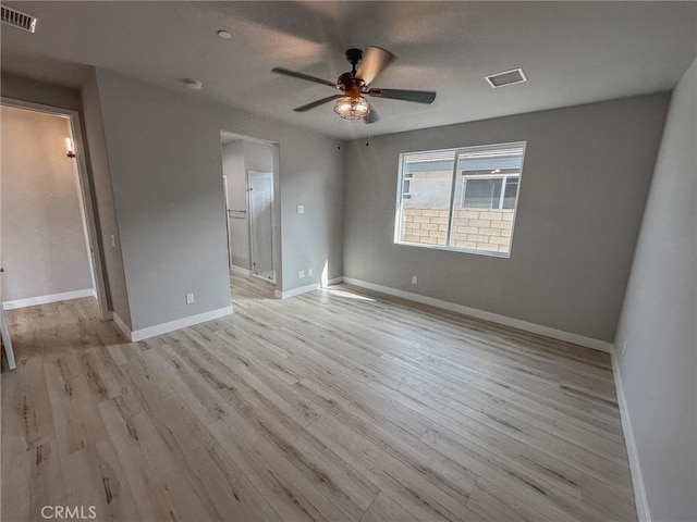 empty room with a ceiling fan, light wood-type flooring, visible vents, and baseboards