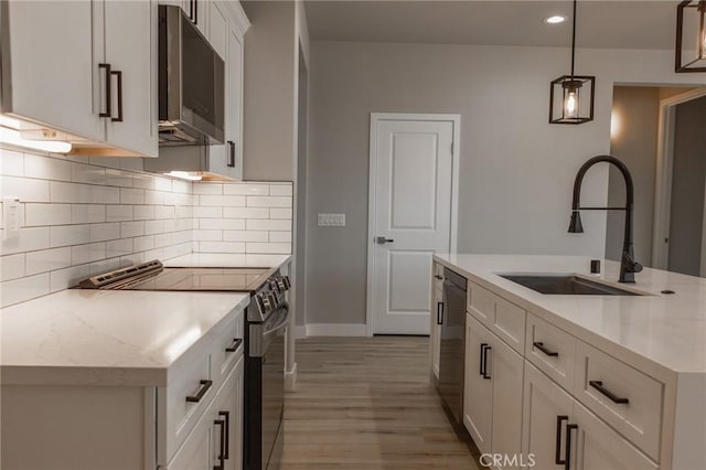 kitchen with stainless steel electric stove, a sink, white cabinetry, hanging light fixtures, and light stone countertops