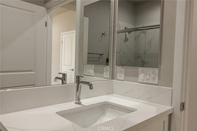 full bathroom featuring vanity and a marble finish shower