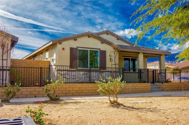 view of front of house featuring a fenced front yard and stucco siding