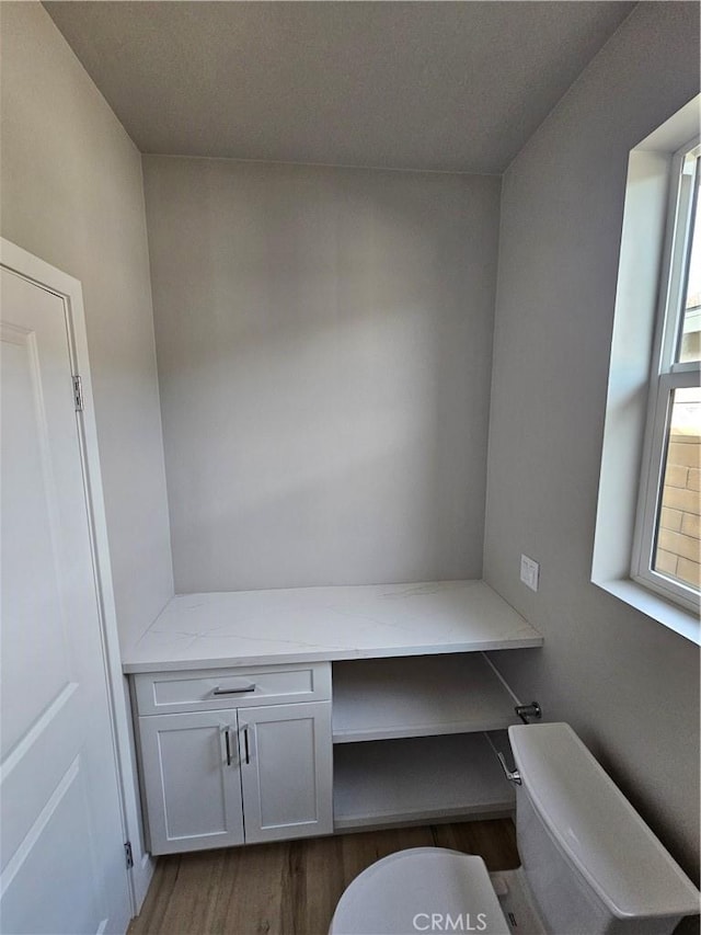 office with dark wood-style floors and built in desk