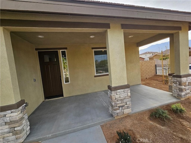 property entrance with fence and stucco siding