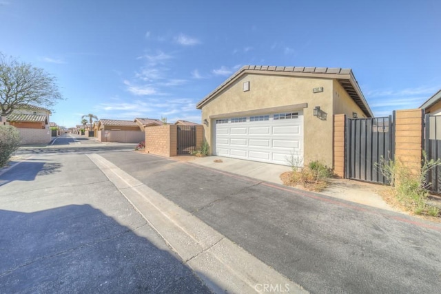 67813 Rio Vista Dr, Cathedral City, CA 92234 - view of front of house with a gate, stucco siding, and a garage