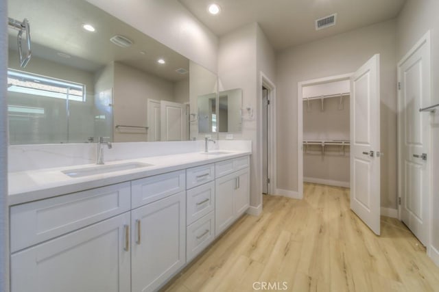 67813 Rio Vista Dr, Cathedral City, CA 92234 - full bath featuring double vanity, wood finished floors, a walk in closet, and recessed lighting