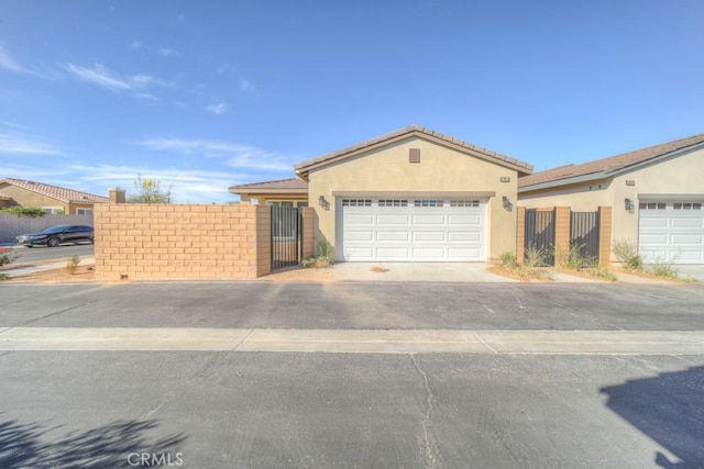 67813 Rio Vista Dr, Cathedral City, CA 92234 - ranch-style home with stucco siding, a garage, asphalt driveway, and a gate